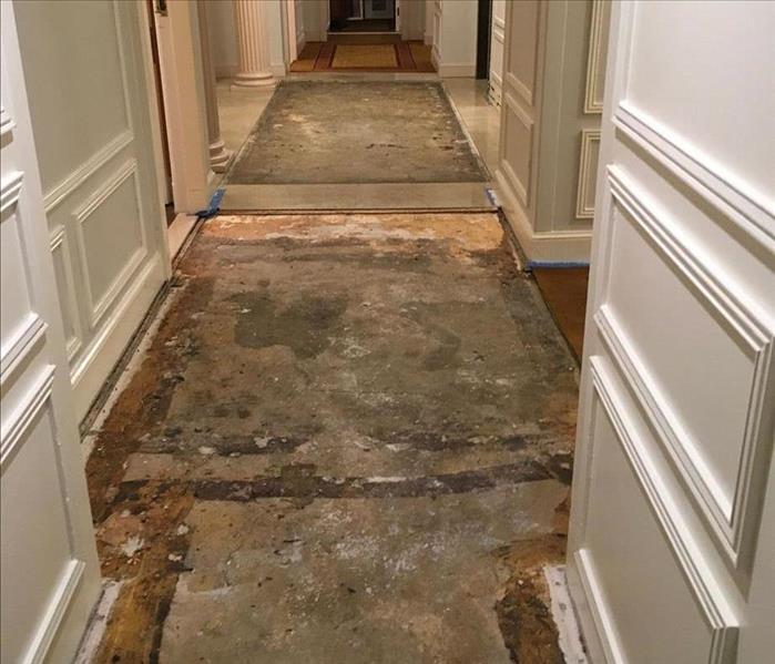 The After Photo depicts the hallway after water-damaged materials have been removed from the hallway, primarily consisting of