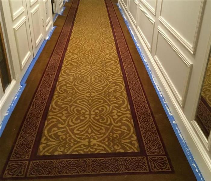 In the Before Photo, moisture has saturated this Upper East Side residence’s hallway carpet and pad. Technicians photograph t