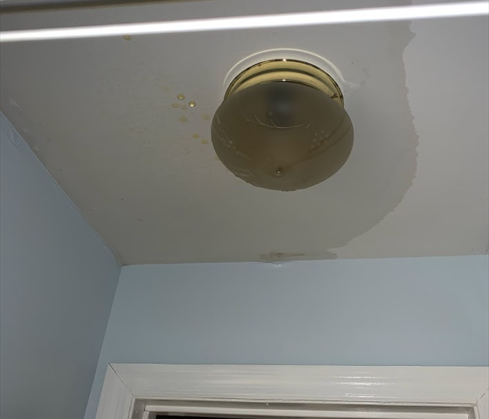 Light fixture with water in the globe and water soaking the surrounding drywall