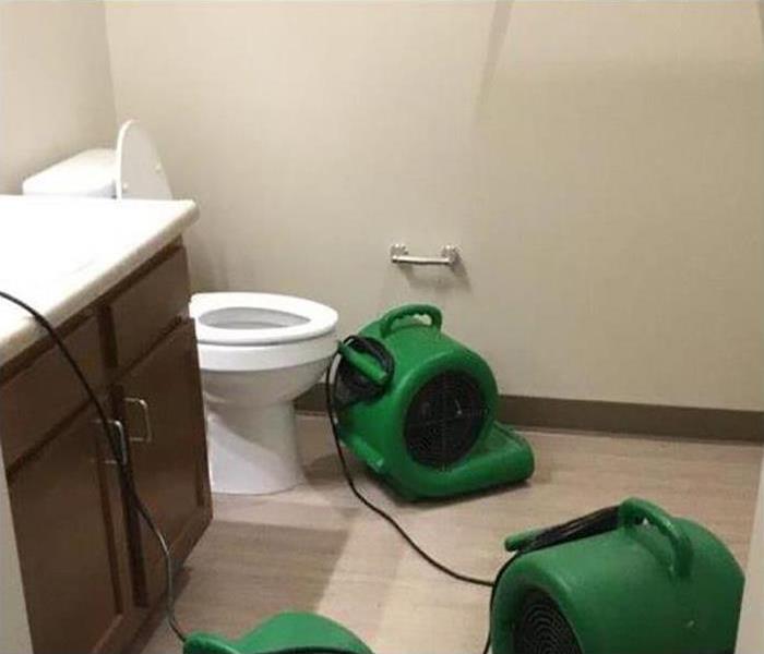 drying equipment in water damaged bathroom