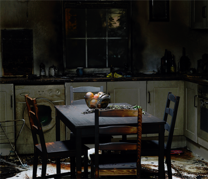 a fire damaged kitchen with soot covering the dining set